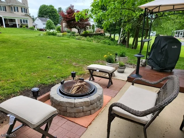 a view of a backyard with table and chairs potted plants and a garden