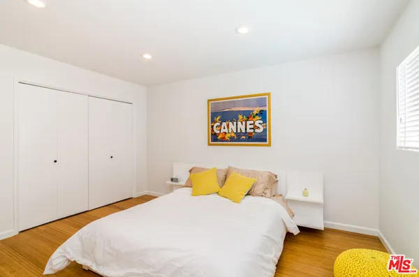 a bedroom with a bed and a painting on the wall