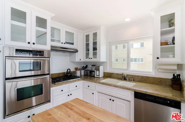 a kitchen with stainless steel appliances white cabinets and a sink