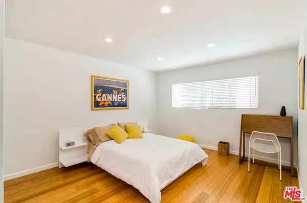 a bedroom with a bed and wooden floor