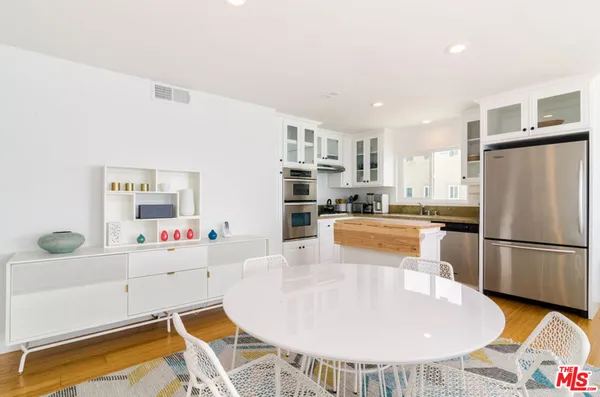 a kitchen with stainless steel appliances granite countertop a sink a stove a refrigerator and cabinets