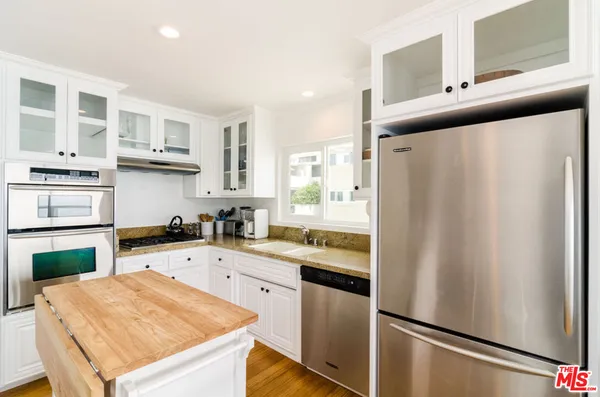 a kitchen with stainless steel appliances a refrigerator sink and cabinets