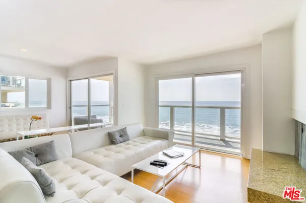 a living room with furniture and floor to ceiling windows