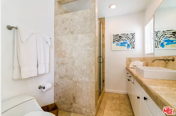 a bathroom with a granite countertop sink a mirror and shower