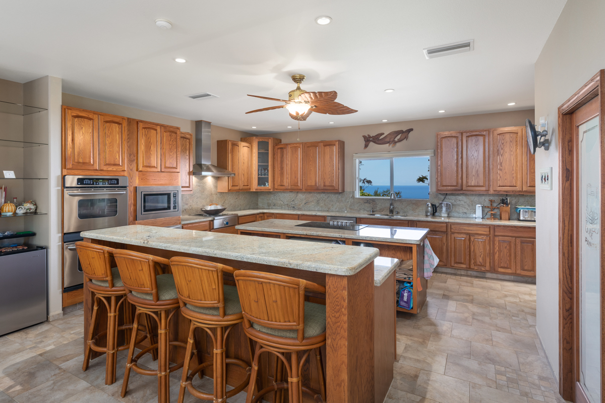 73-4571 Kukuki Street, Unit A Kailua-Kona, HI 96740 - Photo 11 of 30 a kitchen with a table chairs microwave and cabinets