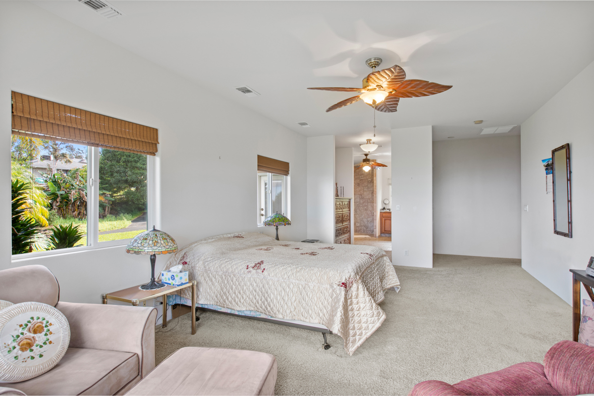 73-4571 Kukuki Street, Unit A Kailua-Kona, HI 96740 - Photo 14 of 30 a bedroom with a bed and a chandelier