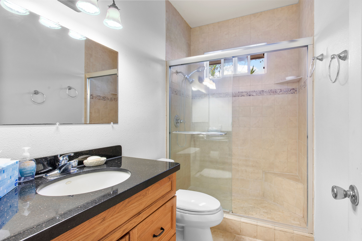 73-4571 Kukuki Street, Unit A Kailua-Kona, HI 96740 - Photo 19 of 30 a bathroom with a granite countertop sink toilet and shower