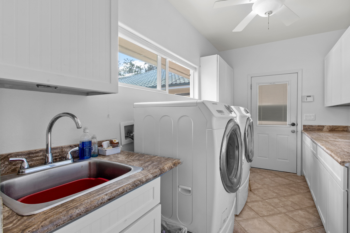 73-4571 Kukuki Street, Unit A Kailua-Kona, HI 96740 - Photo 26 of 30 a kitchen with a sink and a washer dryer