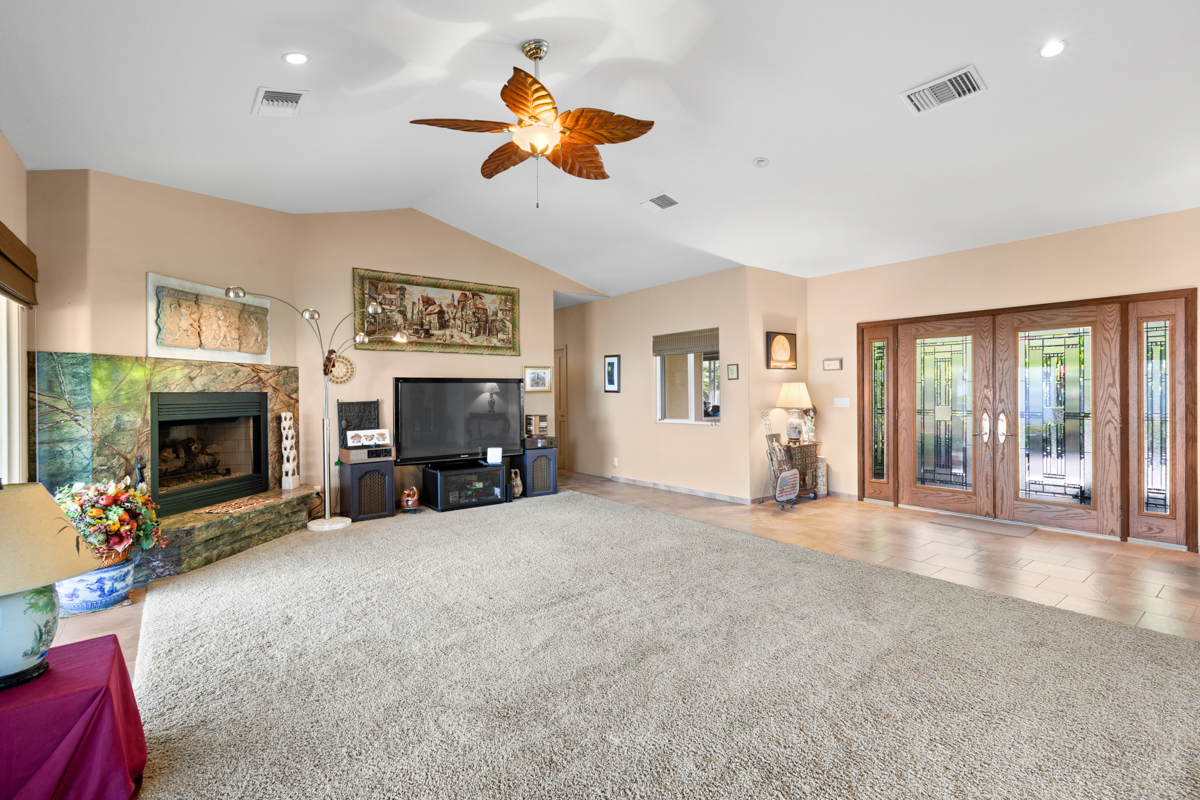 73-4571 Kukuki Street, Unit A Kailua-Kona, HI 96740 - Photo 8 of 30 a view of a livingroom with a fireplace a chandelier fan and windows