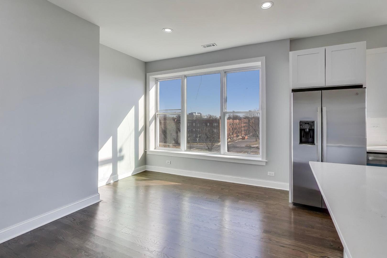 313 East 60th Street, Unit 4 Chicago, IL 60637 - Photo 12 of 42 a view of an empty room with wooden floor and a window