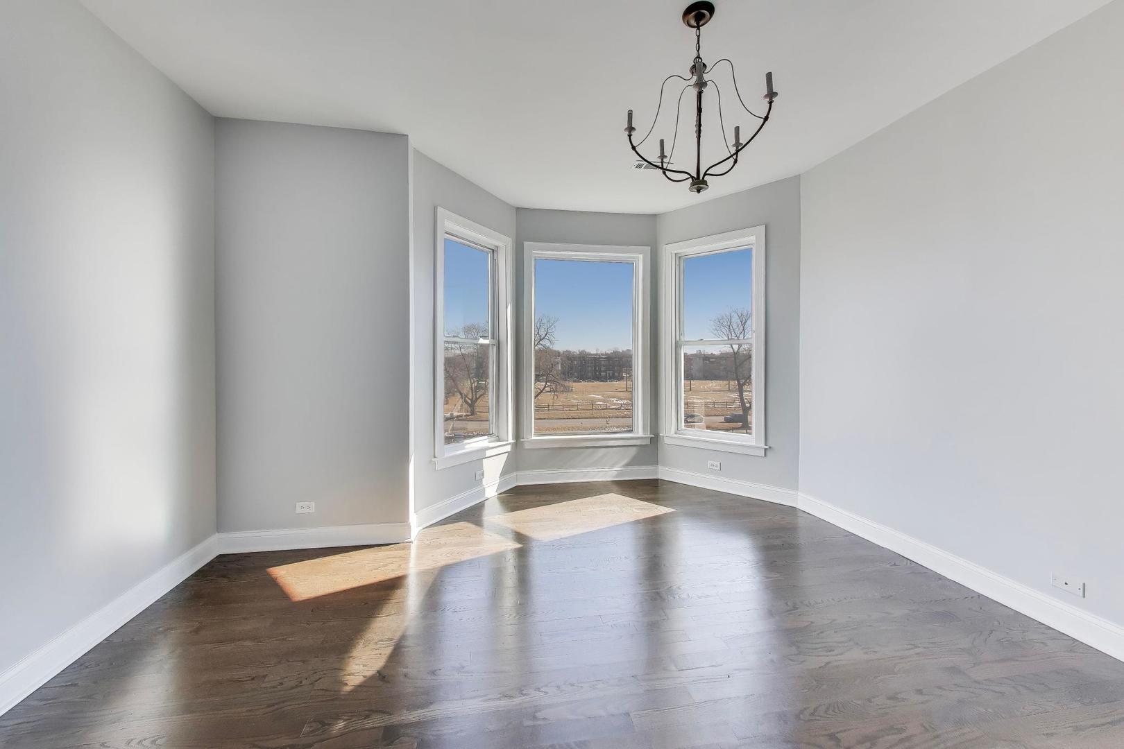 313 East 60th Street, Unit 4 Chicago, IL 60637 - Photo 24 of 42 a view of an empty room with wooden floor and a window