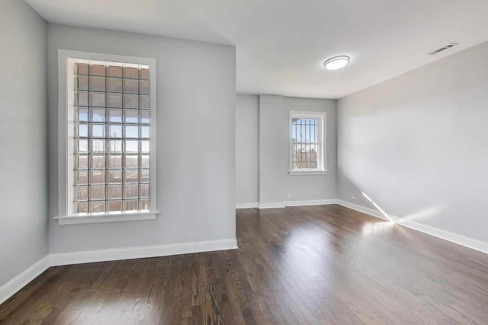 313 East 60th Street, Unit 4 Chicago, IL 60637 - Photo 29 of 42 a view of an empty room with wooden floor and a window