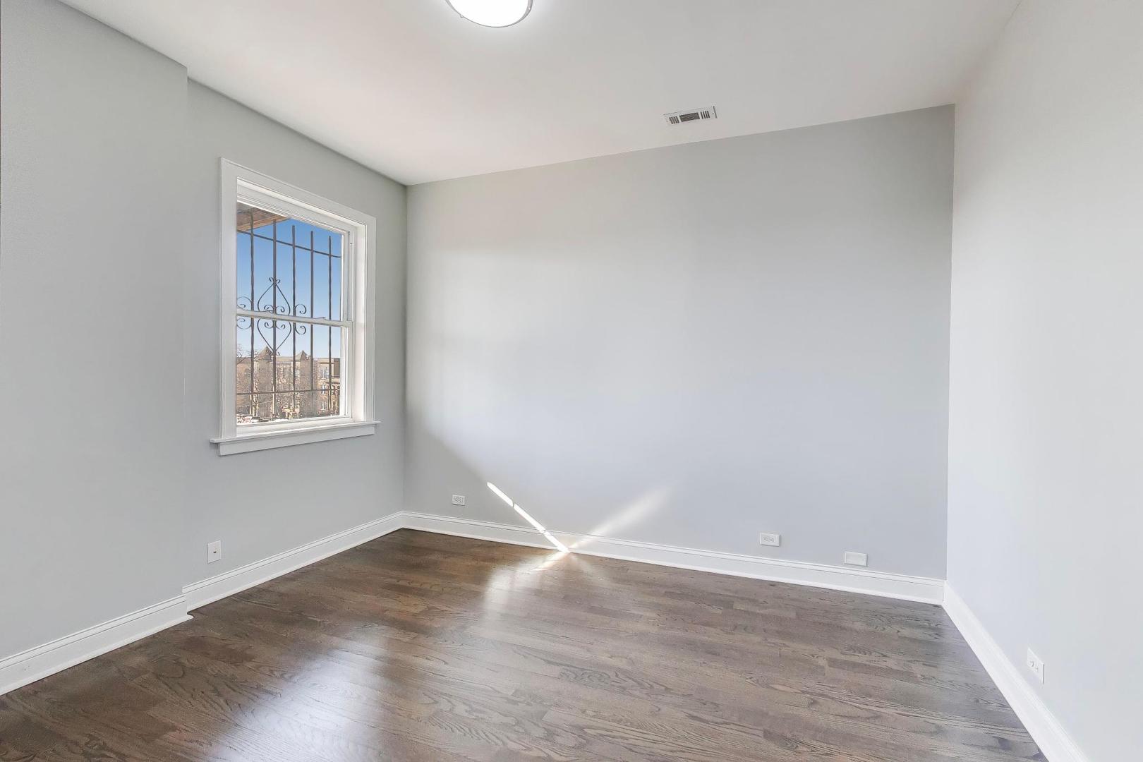 313 East 60th Street, Unit 4 Chicago, IL 60637 - Photo 30 of 42 a view of an empty room with wooden floor and a window