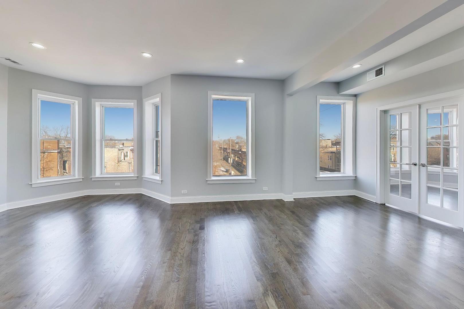 313 East 60th Street, Unit 4 Chicago, IL 60637 - Photo 6 of 42 a view of an empty room with wooden floor and a window
