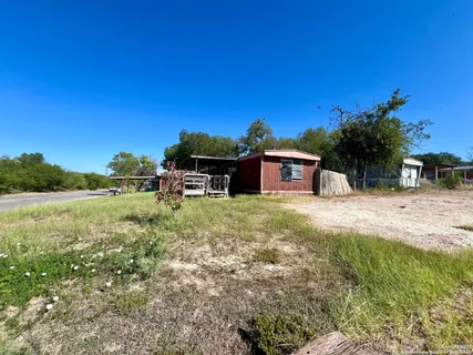 a backyard of a house with table and chairs