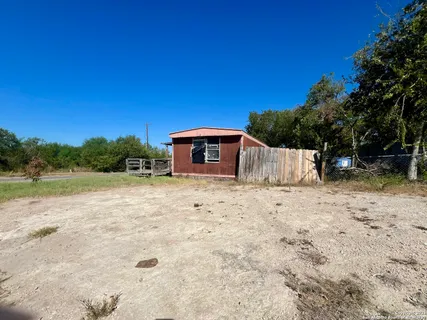 a backyard of a house with large trees and a beach