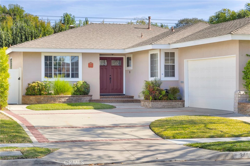 a front view of a house with a yard and potted plants
