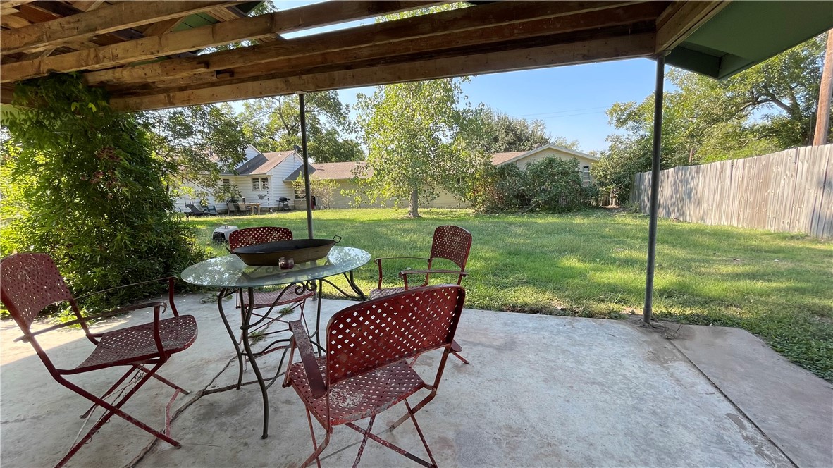 704 Colorado Street Bremond, TX 76629 - Photo 34 of 42 a view of a patio with a table chairs and a backyard