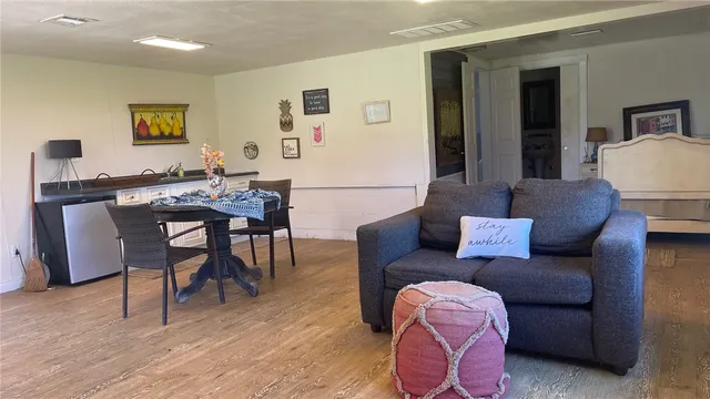 a living room with furniture a wooden floor and a bookshelf