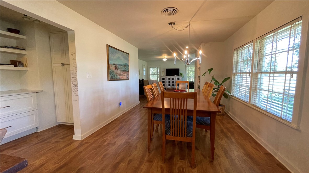 704 Colorado Street Bremond, TX 76629 - Photo 5 of 42 a dining room with wooden floor a chandelier a wooden table and chairs