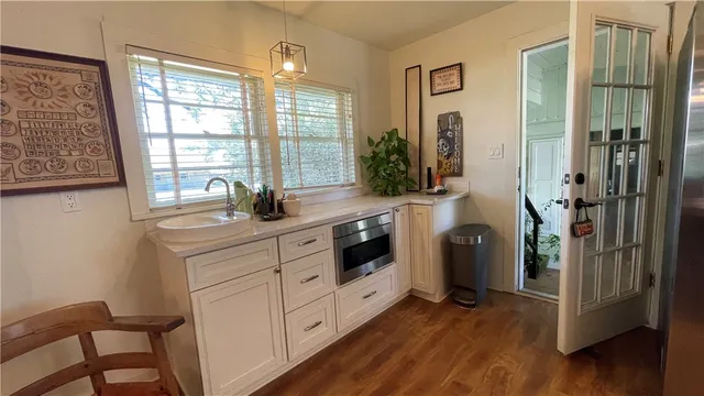 a kitchen with stainless steel appliances a white cabinets and wooden floor
