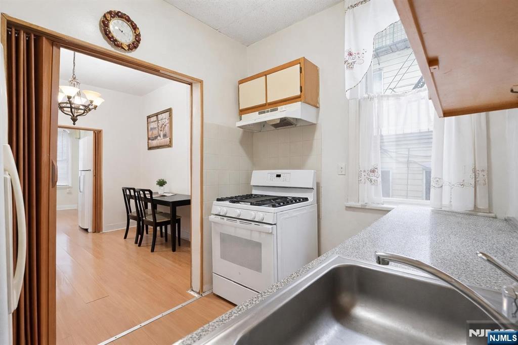 509 Monastery Place Union City, NJ 07087 - Photo 19 of 49 a kitchen that has a stove a table and chairs in it