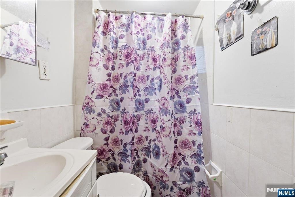 509 Monastery Place Union City, NJ 07087 - Photo 9 of 49 a white toilet sitting next to a shower curtain