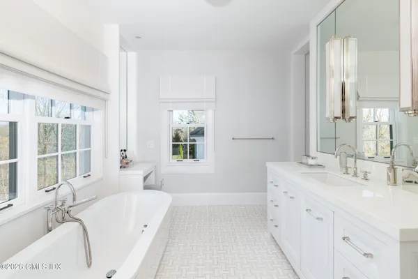 a bathroom with a double vanity sink mirror and shower