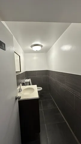 a bathroom with a toilet a sink and mirror