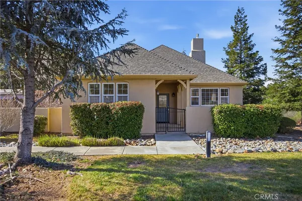 a front view of a house with a yard and potted plants