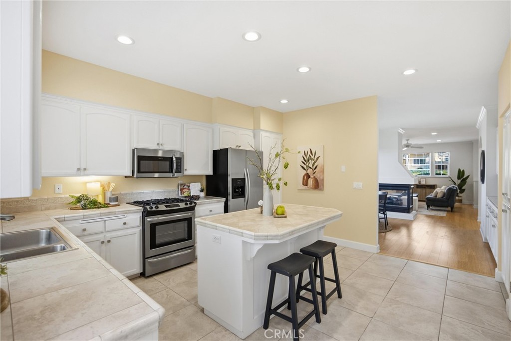 93 Benson Terrace Chico, CA 95928 - Photo 2 of 15 a view of a kitchen with kitchen island stainless steel appliances a stove a sink a refrigerator and a center island