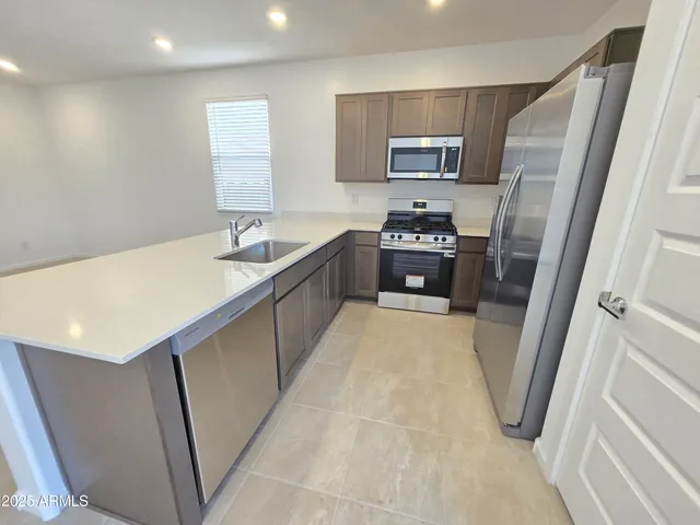 a large kitchen with a sink a refrigerator and a dishwasher