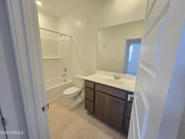 a bathroom with a granite countertop sink a toilet and shower