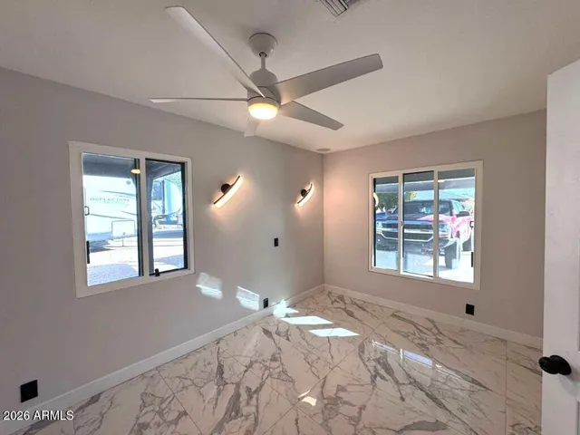 a view of a bedroom with wooden floor and windows