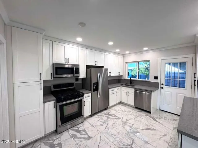 a kitchen with a refrigerator sink and wooden cabinets