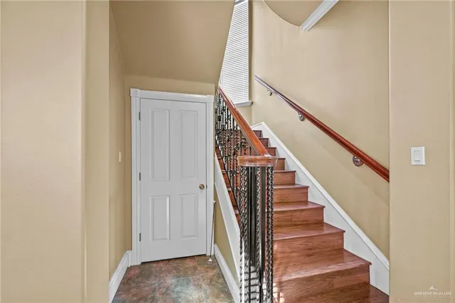 a view of staircase with wooden floor and white walls