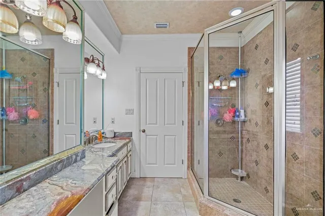 a bathroom with a granite countertop shower a sink and mirror