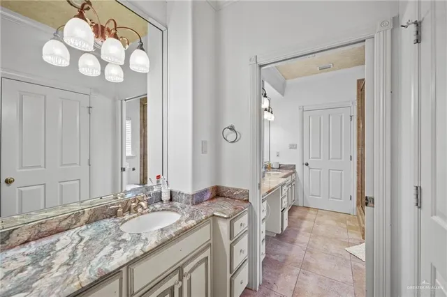 a spacious bathroom with a granite countertop sink a mirror and a vanity