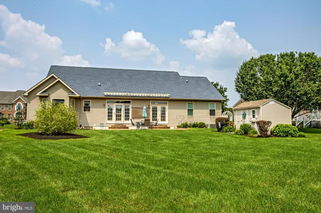 a front view of a house with a yard and trees