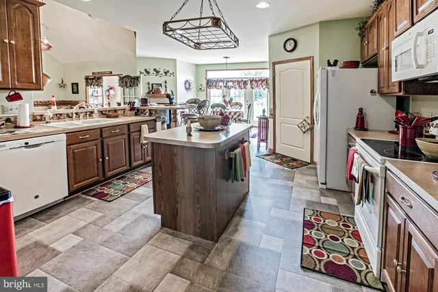 a kitchen with stainless steel appliances kitchen island granite countertop a refrigerator and a stove
