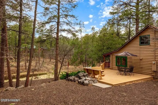 a view of a backyard with sitting area and tree