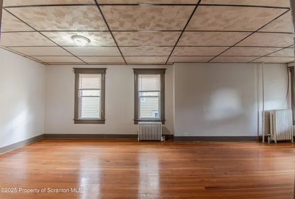 a view of empty room with wooden floor