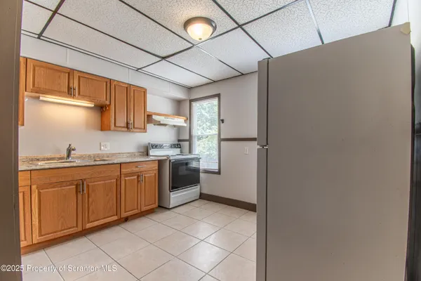 a kitchen with granite countertop a refrigerator and a sink