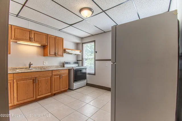 a kitchen with granite countertop a refrigerator and a sink