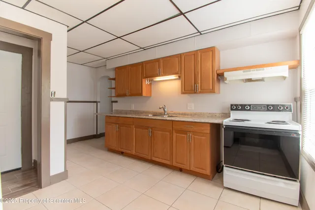 a kitchen with granite countertop stainless steel appliances a stove top oven and cabinets