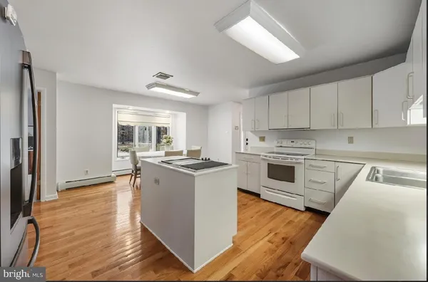 a kitchen that has a table chairs and refrigerator