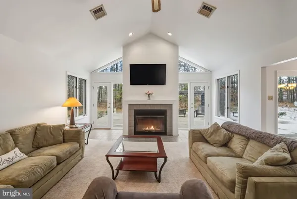 a living room with furniture a fireplace and a flat screen tv