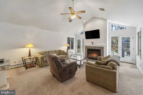 a living room with furniture a flat screen tv and a fireplace