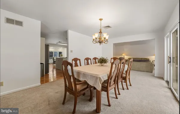 a dining room with furniture a chandelier and window