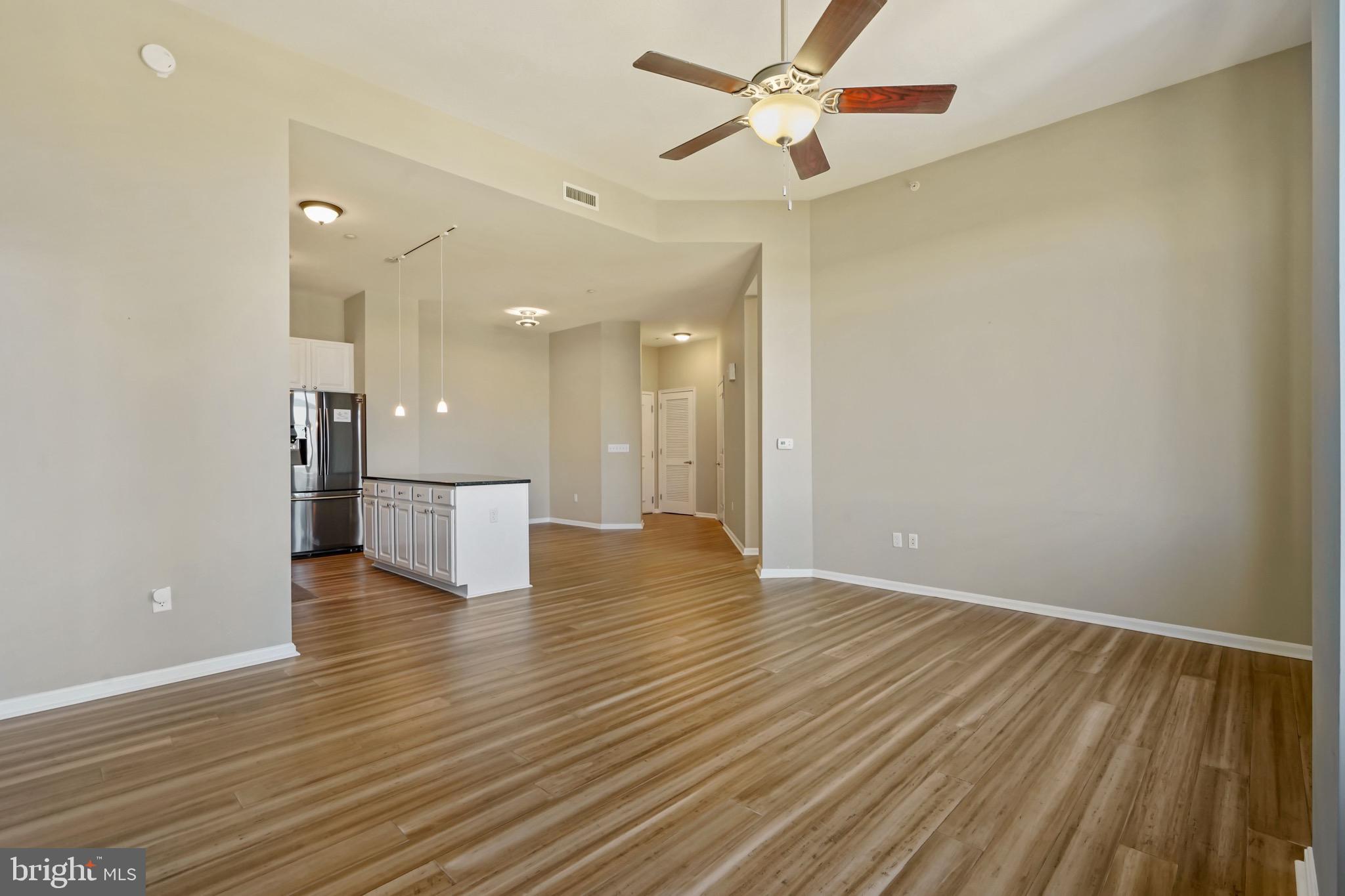 2720 South Arlington Mill Drive, Unit 1102 Arlington, VA 22206 - Photo 13 of 28 an empty room with wooden floor and windows